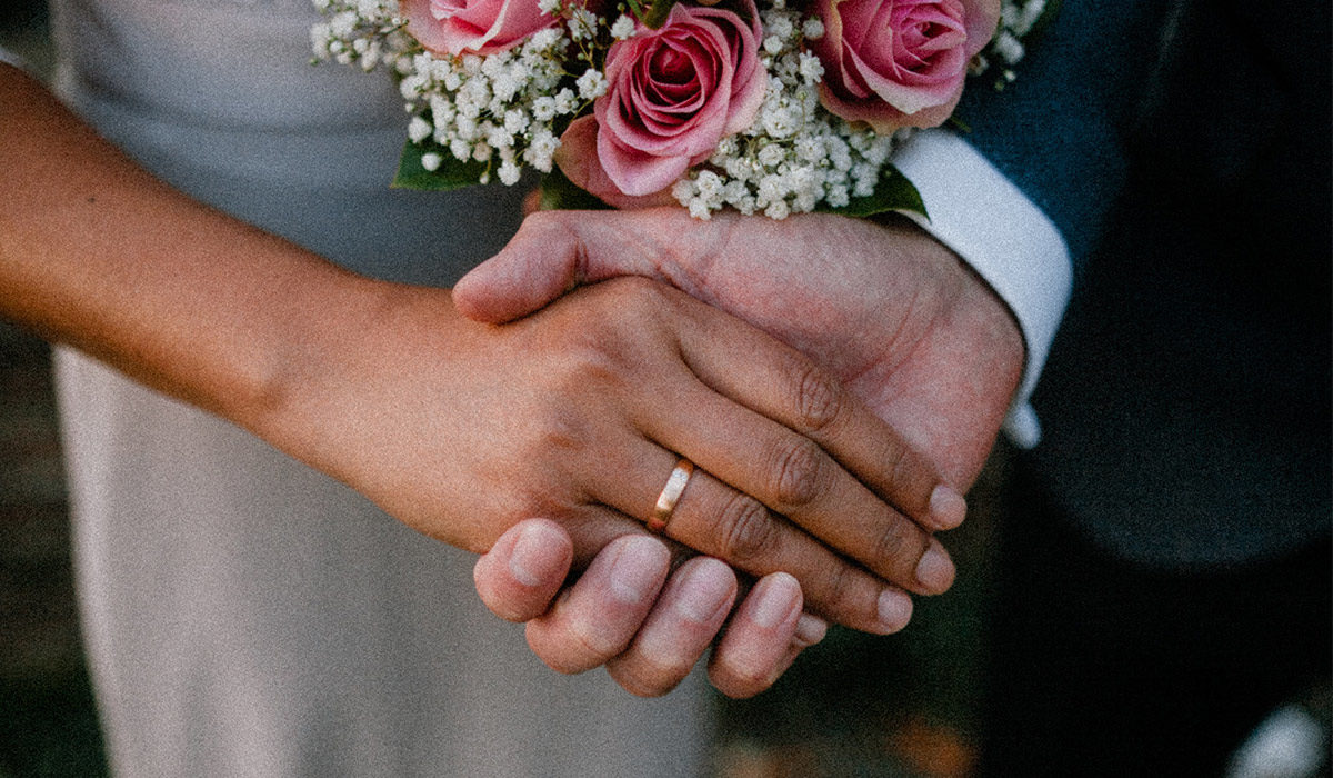 a husband and wife holding hands on their wedding day