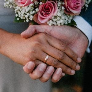 a husband and wife holding hands on their wedding day
