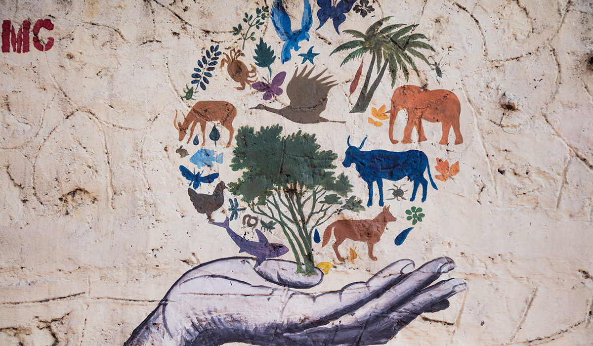 a painting of a hand holding symbols that represent the world