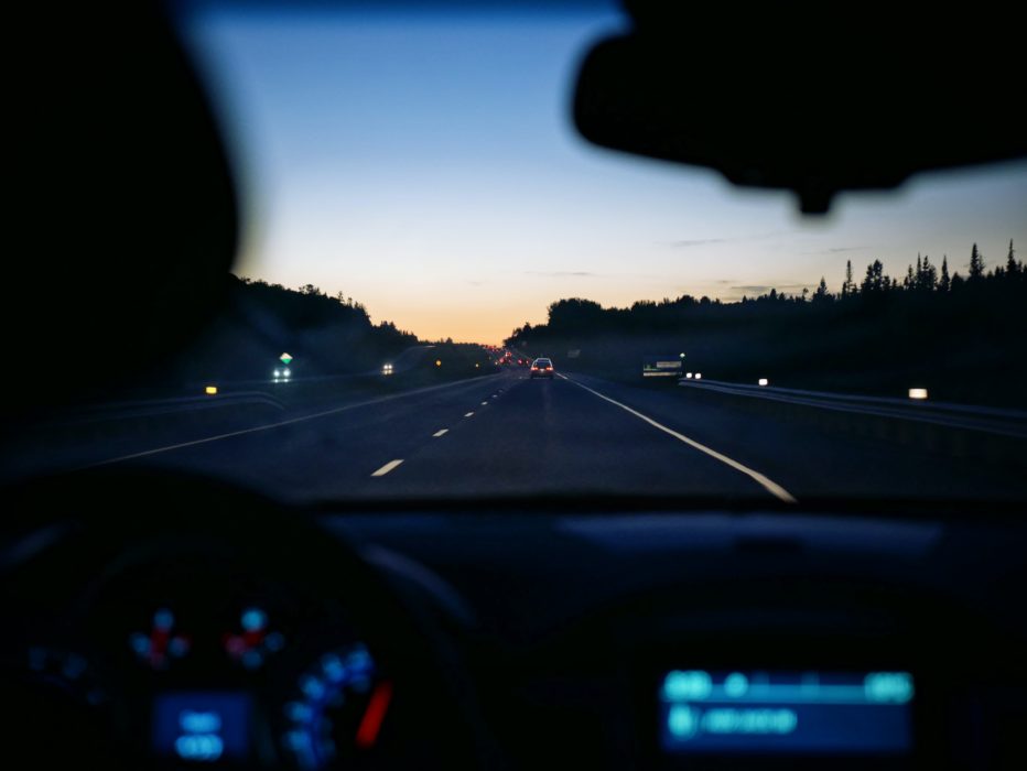 a photo looking out at a sunset through a car dashboard