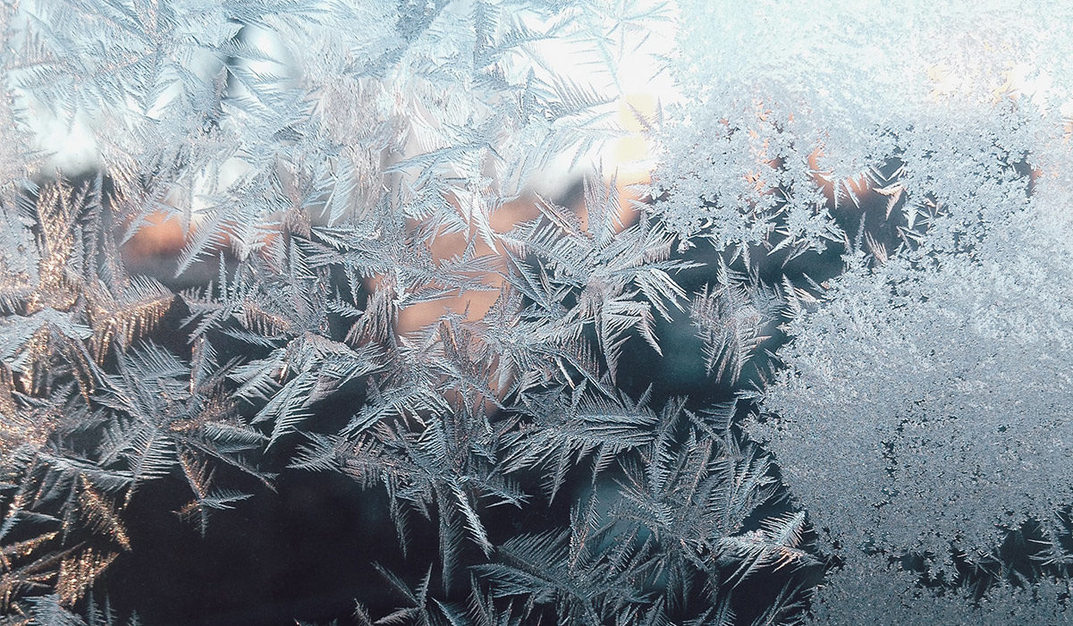 a window with snowflakes of frost covering the pane