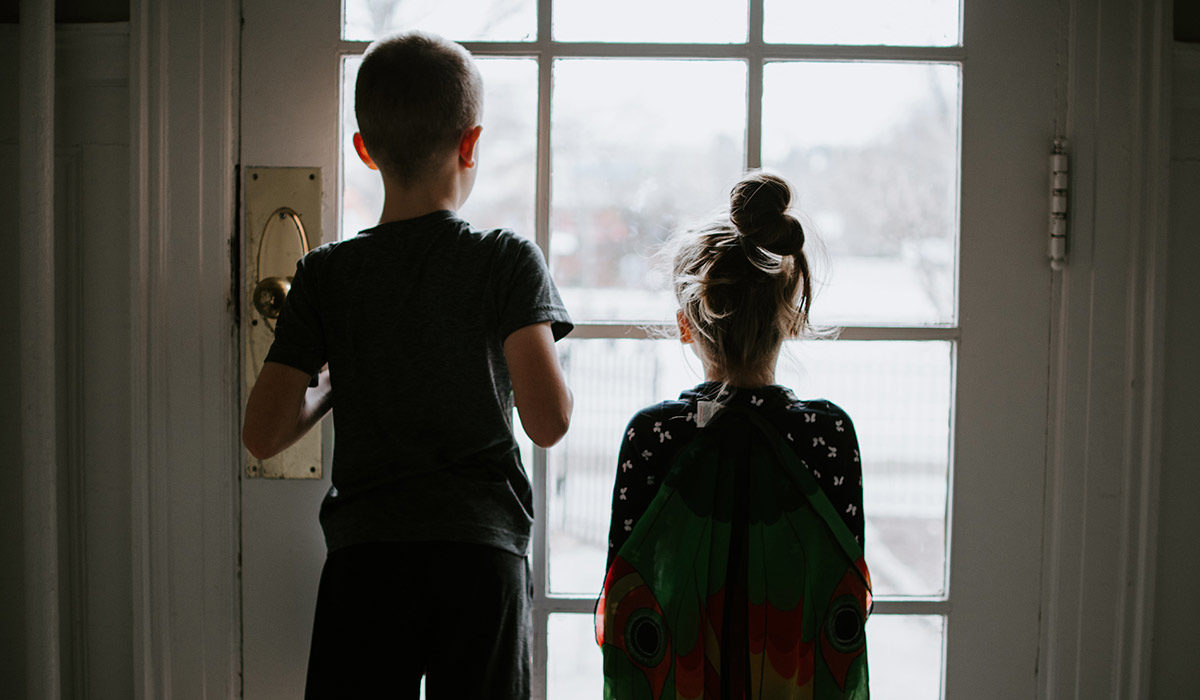 two children looking out of a window