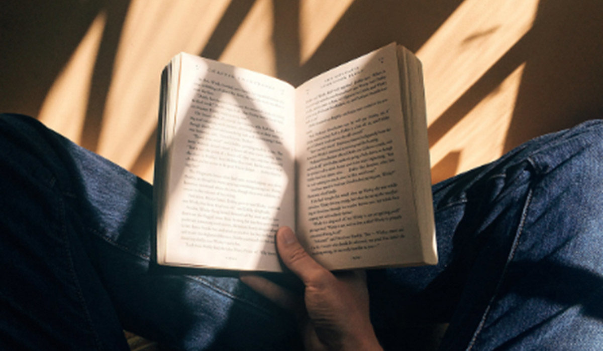 a person's hand holding an open book